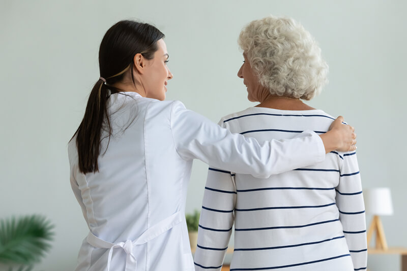 Senior woman walking and talking with a female physician