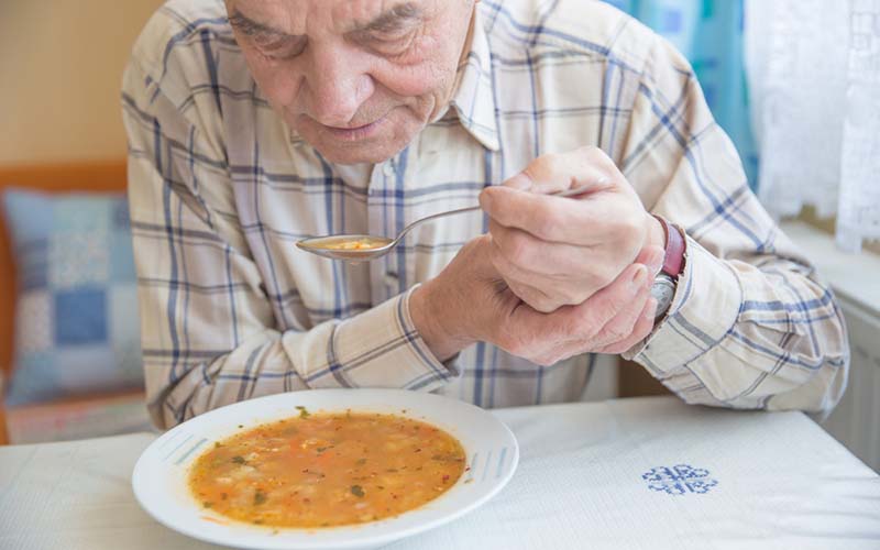 man-holding-hand-while-eating-soup.jpg